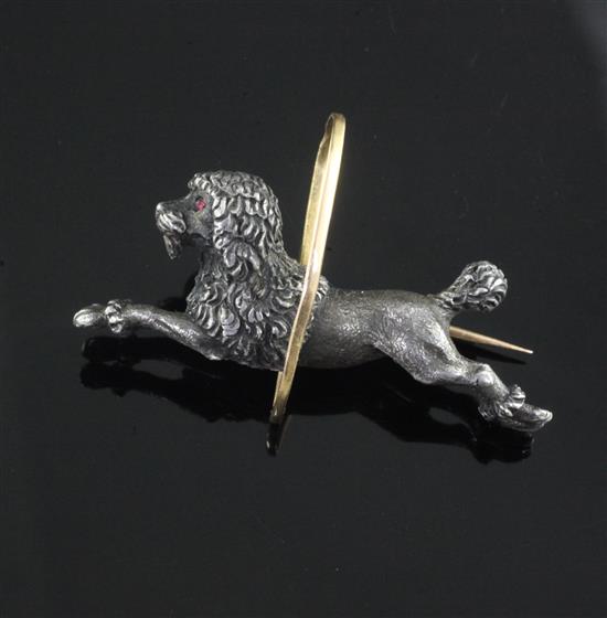 An early 20th century French 18ct gold and white metal novelty brooch, modelled as a poodle jumping through a hoop, 4cm.
